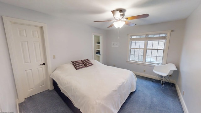 bedroom with ceiling fan, dark carpet, and baseboards