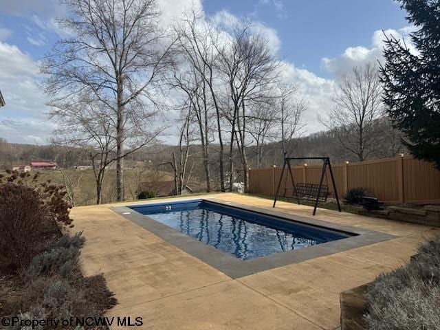 view of swimming pool featuring a playground, a patio area, fence, and a fenced in pool