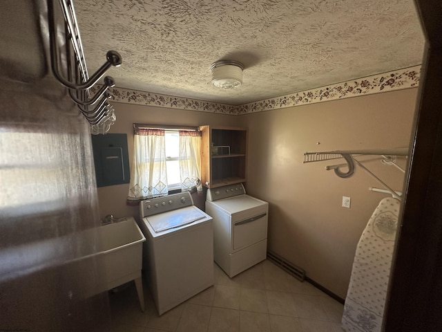 clothes washing area featuring laundry area, electric panel, washing machine and clothes dryer, a textured ceiling, and light tile patterned flooring