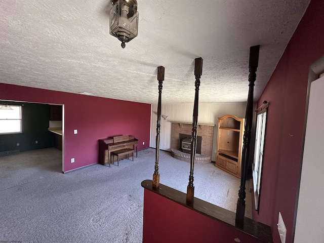 unfurnished bedroom with visible vents, carpet floors, a textured ceiling, and a wood stove