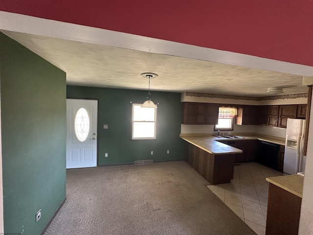 kitchen with a peninsula, a sink, visible vents, light countertops, and white fridge with ice dispenser