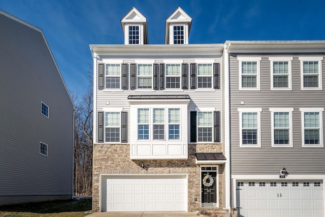 view of property with a garage, a standing seam roof, metal roof, and concrete driveway