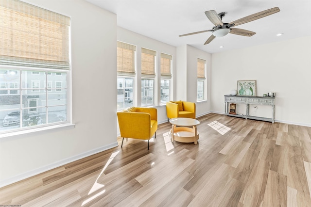 sitting room featuring light wood-style floors, ceiling fan, and baseboards