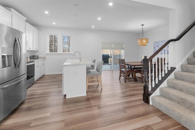 kitchen featuring recessed lighting, a sink, light wood-style floors, light countertops, and appliances with stainless steel finishes