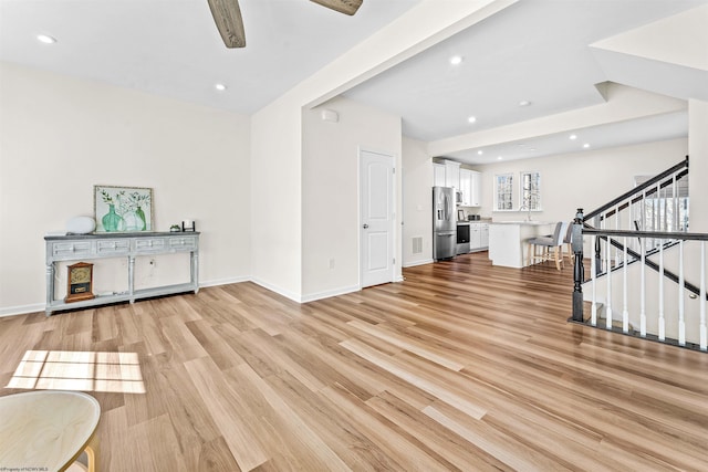 interior space featuring light wood-type flooring, baseboards, recessed lighting, and stairs