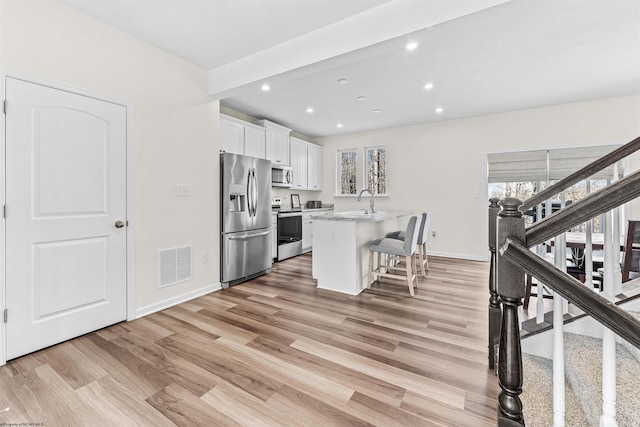 kitchen with a healthy amount of sunlight, white cabinetry, visible vents, and appliances with stainless steel finishes