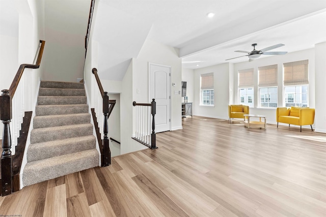 stairs featuring a ceiling fan, baseboards, and wood finished floors