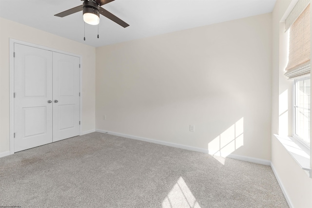 unfurnished bedroom featuring a ceiling fan, a closet, baseboards, and carpet flooring