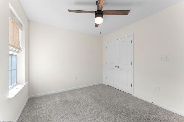 unfurnished bedroom with ceiling fan, carpet floors, a closet, and baseboards