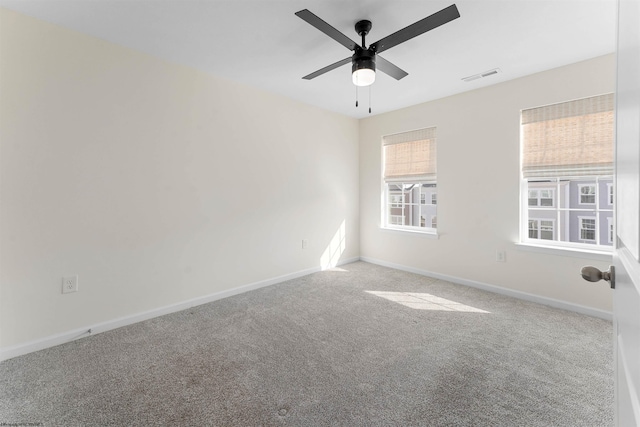 unfurnished room featuring carpet floors, ceiling fan, visible vents, and baseboards