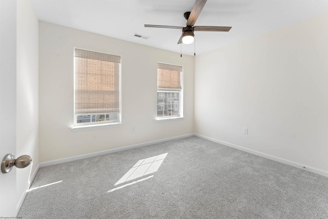 empty room featuring carpet floors, baseboards, visible vents, and a ceiling fan