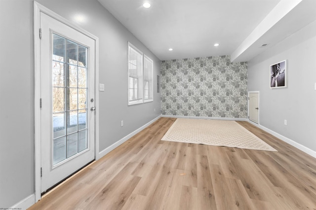 spare room with light wood-style flooring, recessed lighting, an accent wall, baseboards, and wallpapered walls