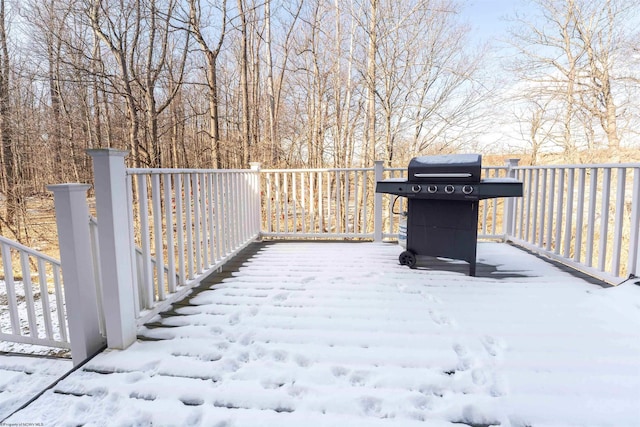 snow covered deck with a grill