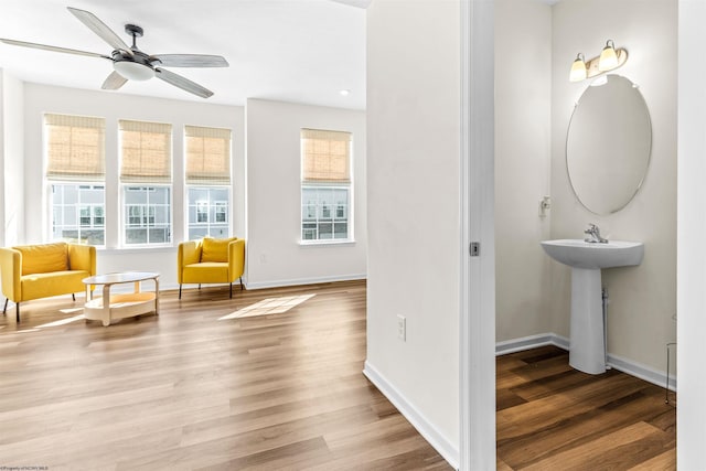 unfurnished room featuring a ceiling fan, a wealth of natural light, baseboards, and wood finished floors