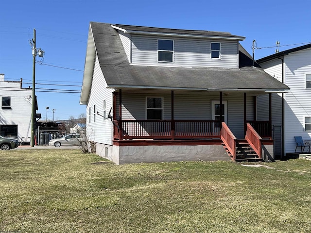 view of front of house with a front yard, covered porch, and roof with shingles