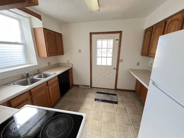 kitchen with visible vents, electric range oven, freestanding refrigerator, a sink, and dishwasher