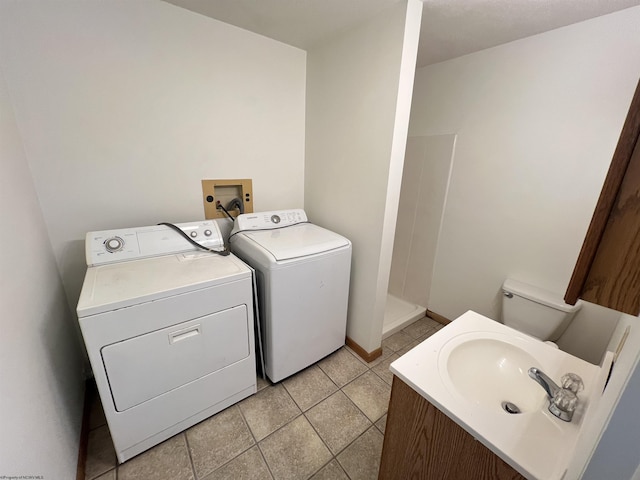 laundry area featuring light tile patterned floors, laundry area, independent washer and dryer, and a sink