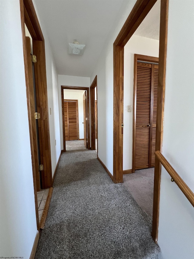 hall featuring light carpet and baseboards