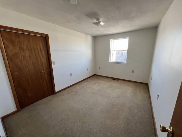 unfurnished bedroom with light carpet and baseboards