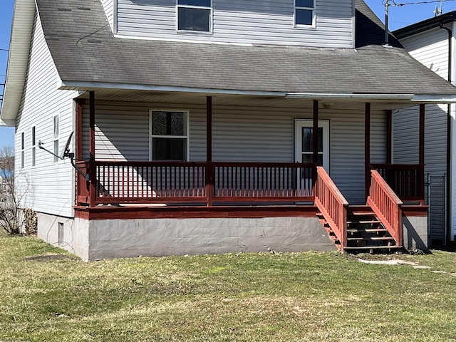 back of property featuring covered porch, a lawn, and roof with shingles