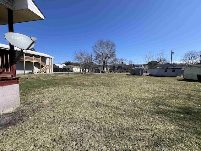 view of yard with a storage shed, stairway, and an outbuilding