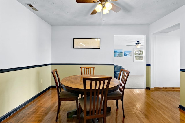 dining room with hardwood / wood-style flooring, baseboards, and visible vents