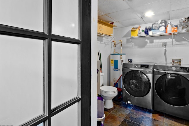 washroom featuring laundry area, water heater, stone finish floor, and independent washer and dryer