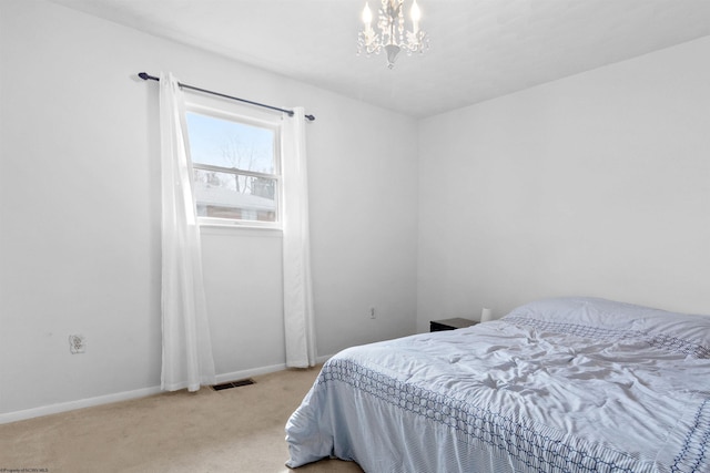 bedroom with visible vents, light carpet, baseboards, and an inviting chandelier