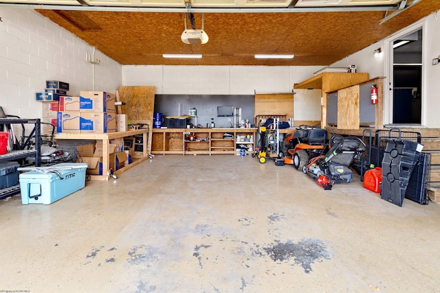 garage featuring a garage door opener and concrete block wall