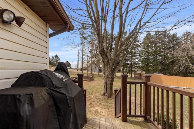 wooden terrace featuring fence, a lawn, and area for grilling