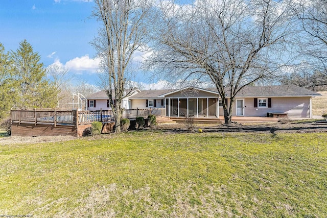 back of house with a deck, a yard, and a sunroom