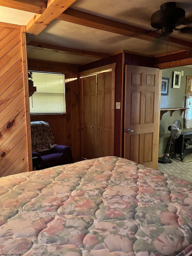 bedroom featuring beamed ceiling and wood walls