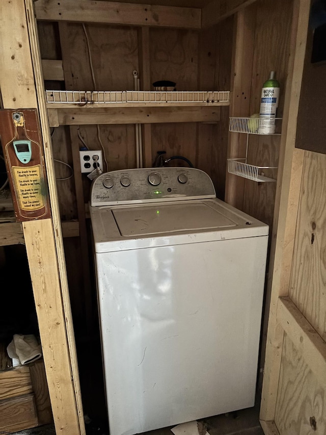 laundry area with laundry area, washer / dryer, and wooden walls