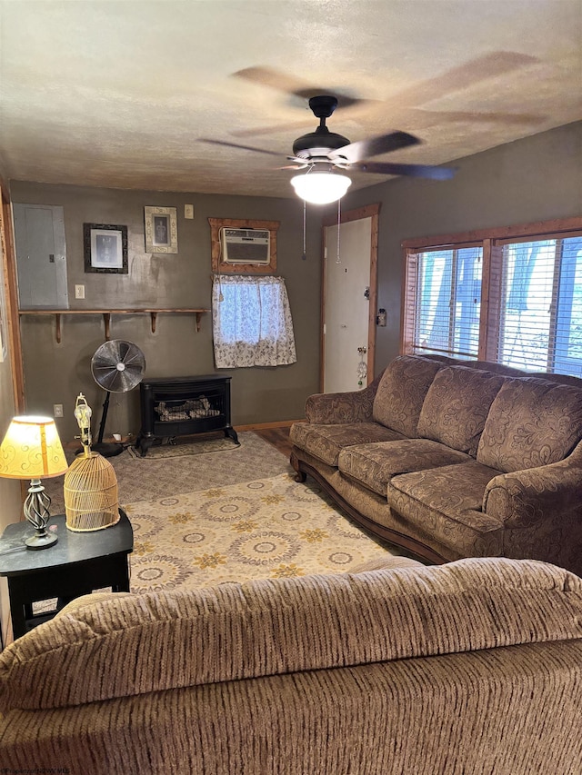 living room with a wall unit AC and ceiling fan