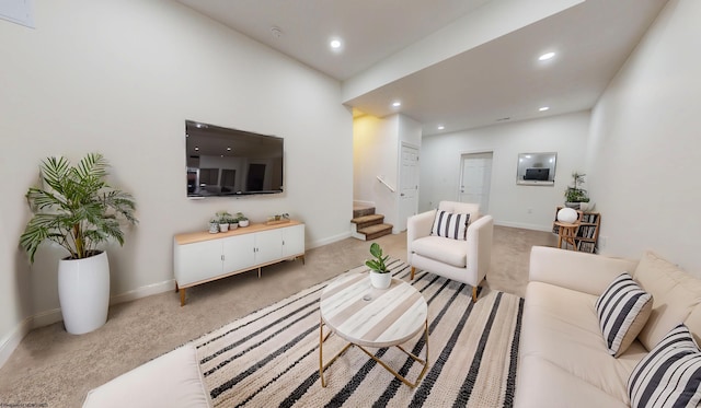 living area featuring carpet floors, stairs, baseboards, and recessed lighting