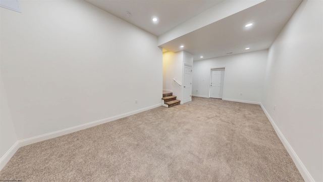 below grade area with recessed lighting, light carpet, baseboards, and stairs