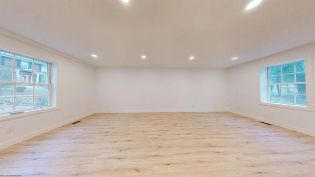 spare room with light wood-type flooring, baseboards, visible vents, and recessed lighting