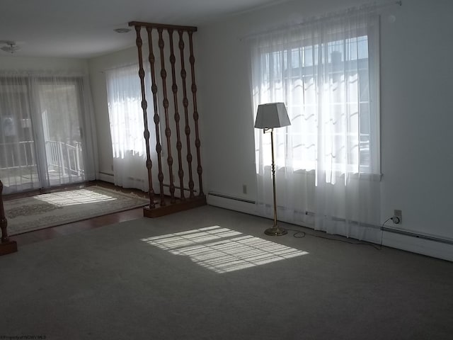 spare room with a baseboard heating unit and carpet flooring