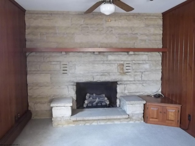 interior details featuring a stone fireplace and a ceiling fan