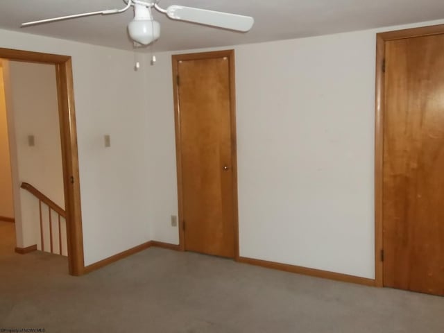 empty room featuring baseboards, carpet, and ceiling fan