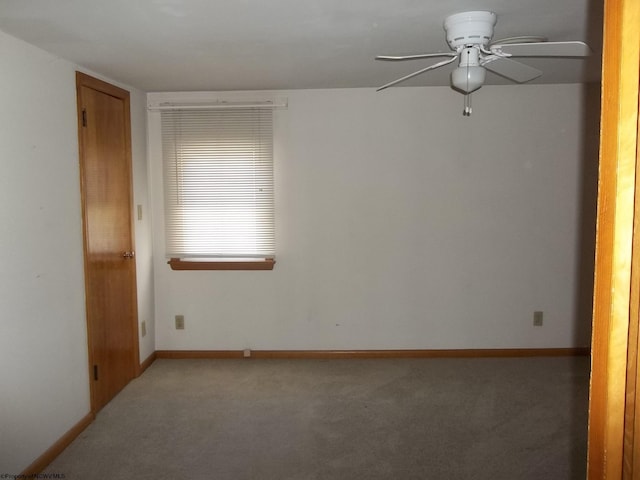 empty room featuring baseboards, a ceiling fan, and carpet flooring