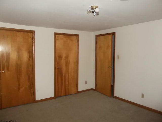 unfurnished bedroom featuring baseboards and light carpet