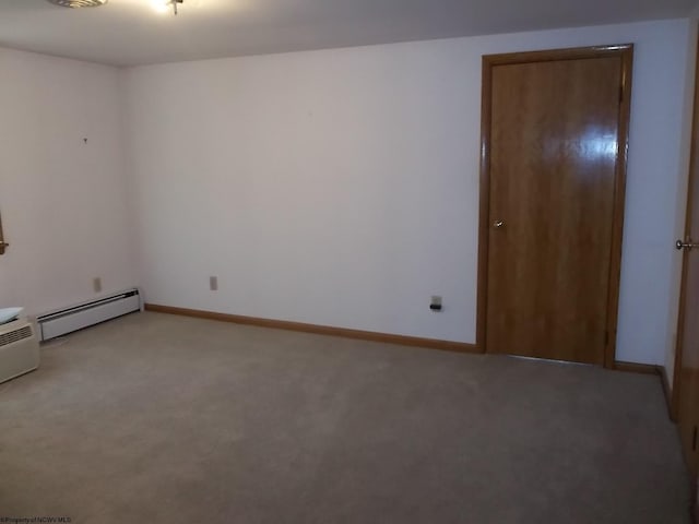 empty room featuring a baseboard radiator, baseboards, and light colored carpet