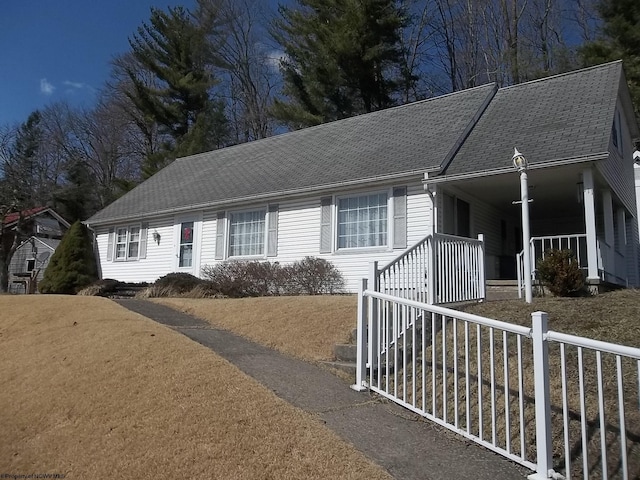 ranch-style home with a porch and a shingled roof