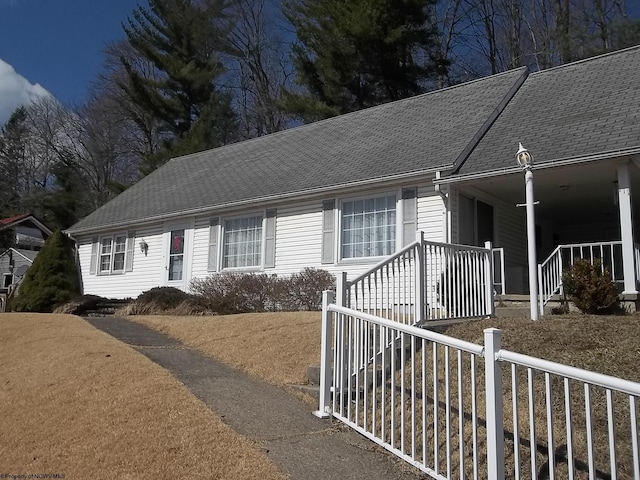 view of front facade with covered porch and a shingled roof