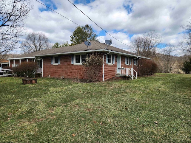 view of side of home featuring a lawn and brick siding