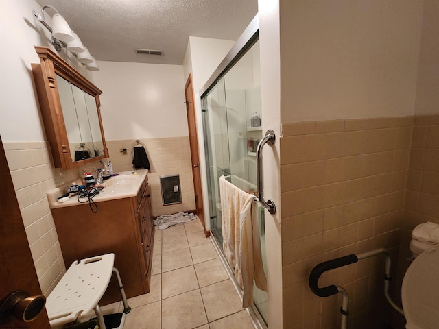 168 Locust Heights Dr, Clarksburg, WV 26301 - bathroom featuring tile patterned flooring, tile walls, vanity, a stall shower, and a textured ceiling
