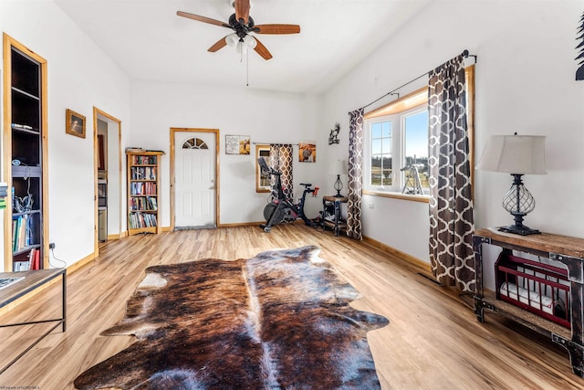 workout room featuring ceiling fan, baseboards, and wood finished floors