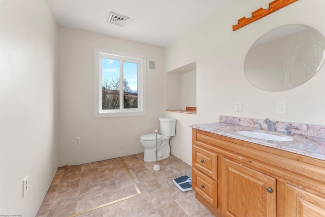 bathroom featuring vanity, toilet, and visible vents