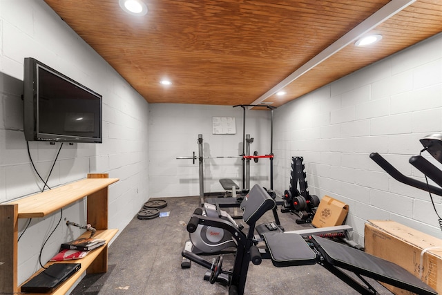 exercise room featuring wooden ceiling, concrete block wall, and recessed lighting